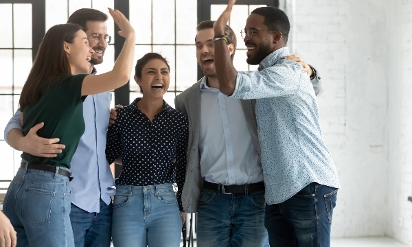 Group of colleagues high-fiving and showing recognition and appreciation to each other.