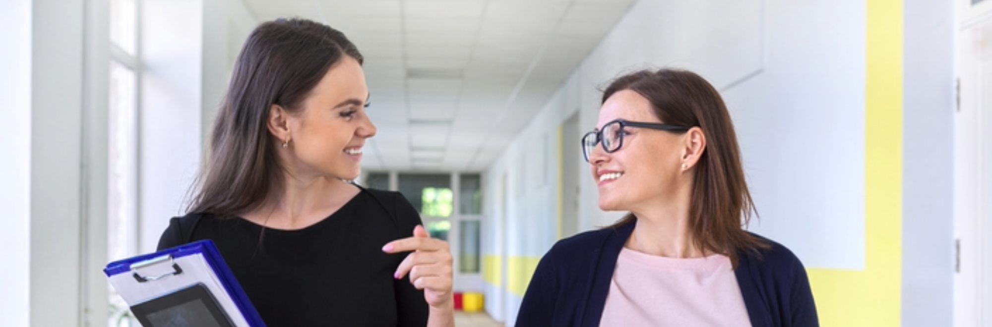 A female leader in school hallway working to develop a fellow leader.